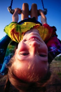 Girl Swinging Upside Down on a Swing